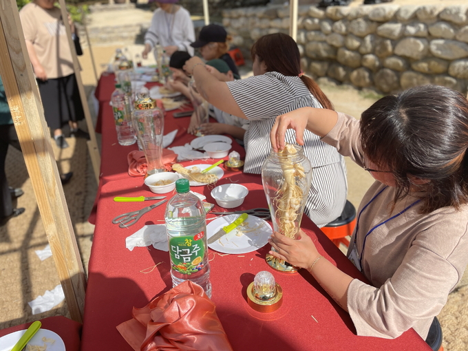 명가명주 프로그램 참여자가 인삼을 활용한 전통주 빚기 체험을 하고 있다.