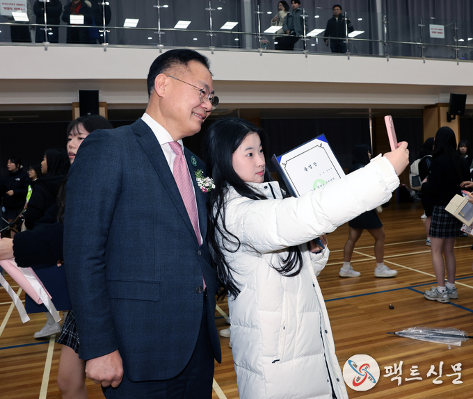 김재욱 칠곡군수가 순심여중 3학년 졸업생 강라윤 양과 함께 졸업식장에서 셀카를 찍고 있다. SNS 인증샷 문화가 졸업식의 새로운 트렌드로 자리 잡고 있다.”